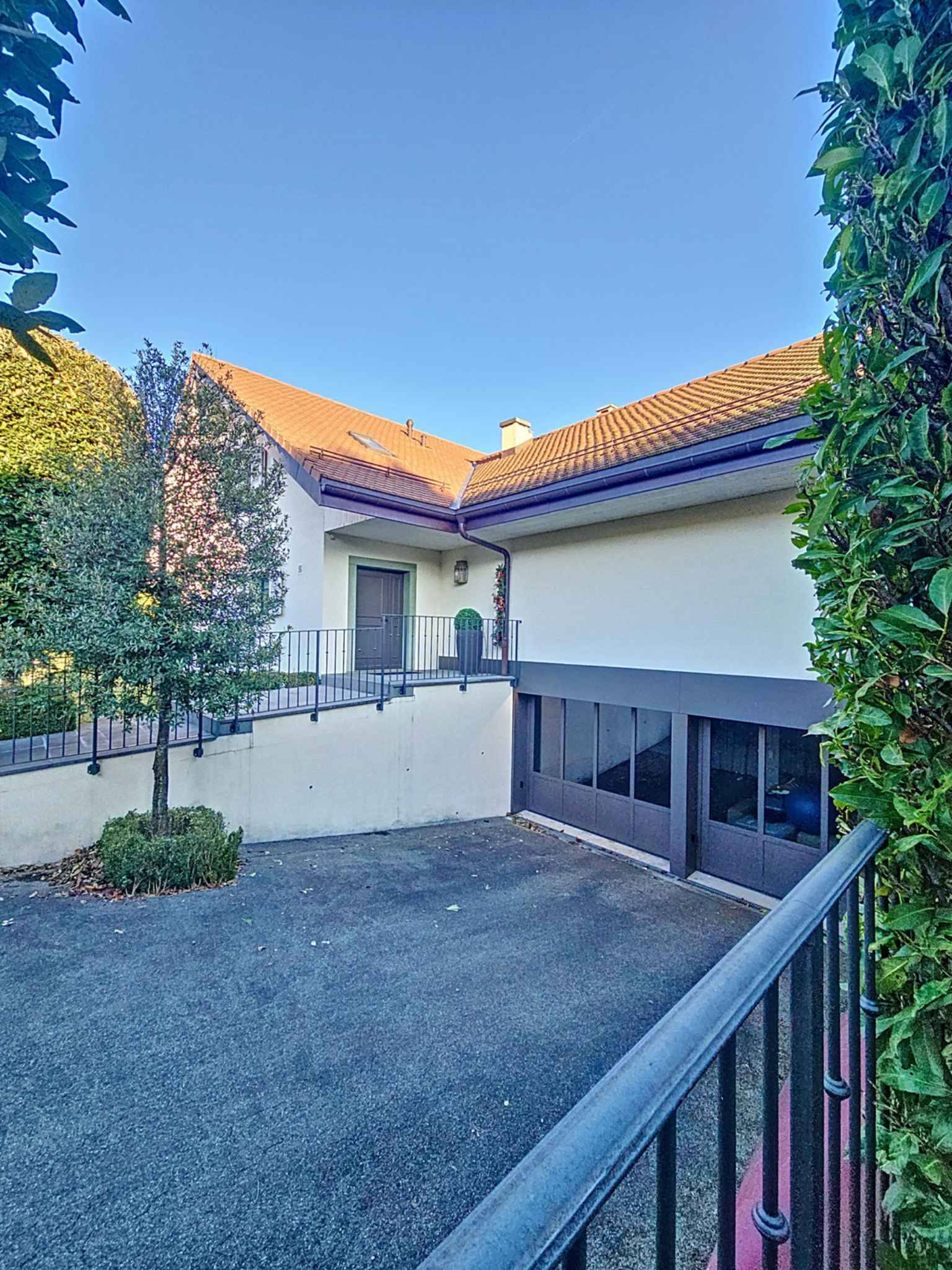 Außenansicht eines Wohnhauses mit Terrasse und Zufahrt