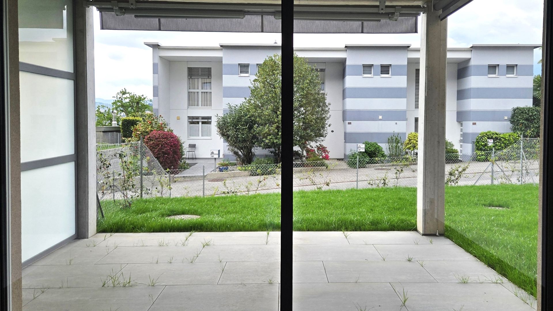 Blick von einer Terrasse in einen begrünten Innenhof