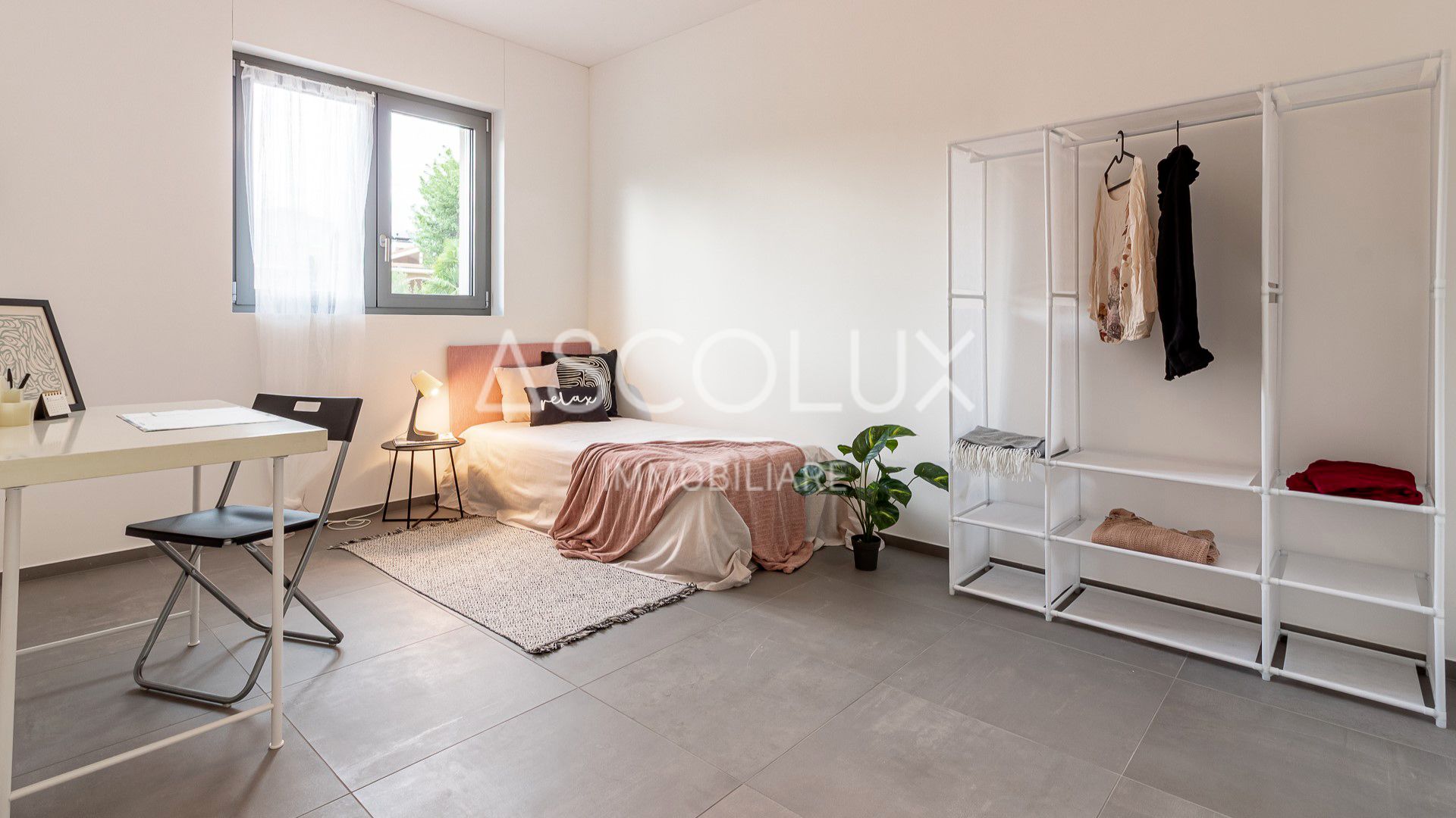 Helles, minimalistisch eingerichtetes Schlafzimmer mit Arbeitsbereich