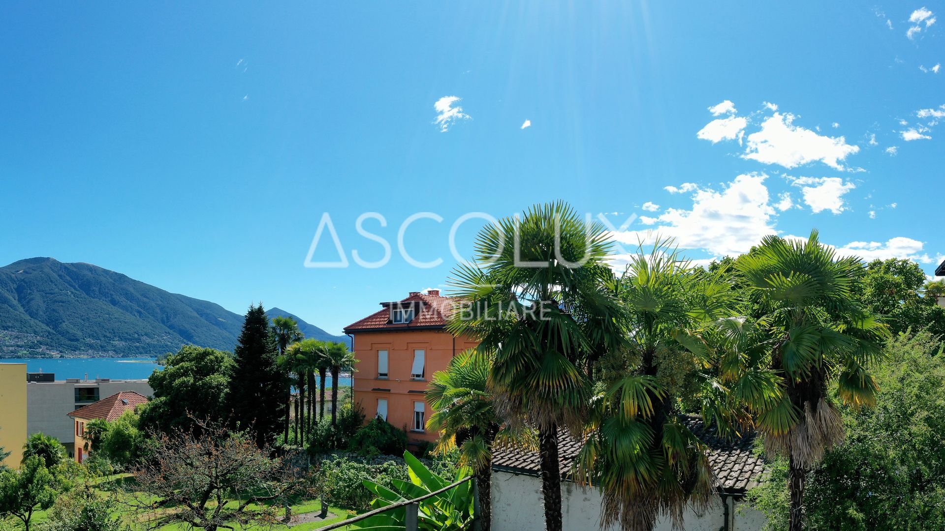 See- und Bergblick mit Palmen und mediterraner Bebauung