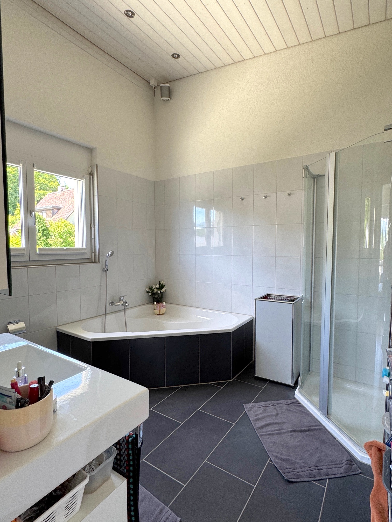 Helles Badezimmer mit Eckbadewanne und Dusche