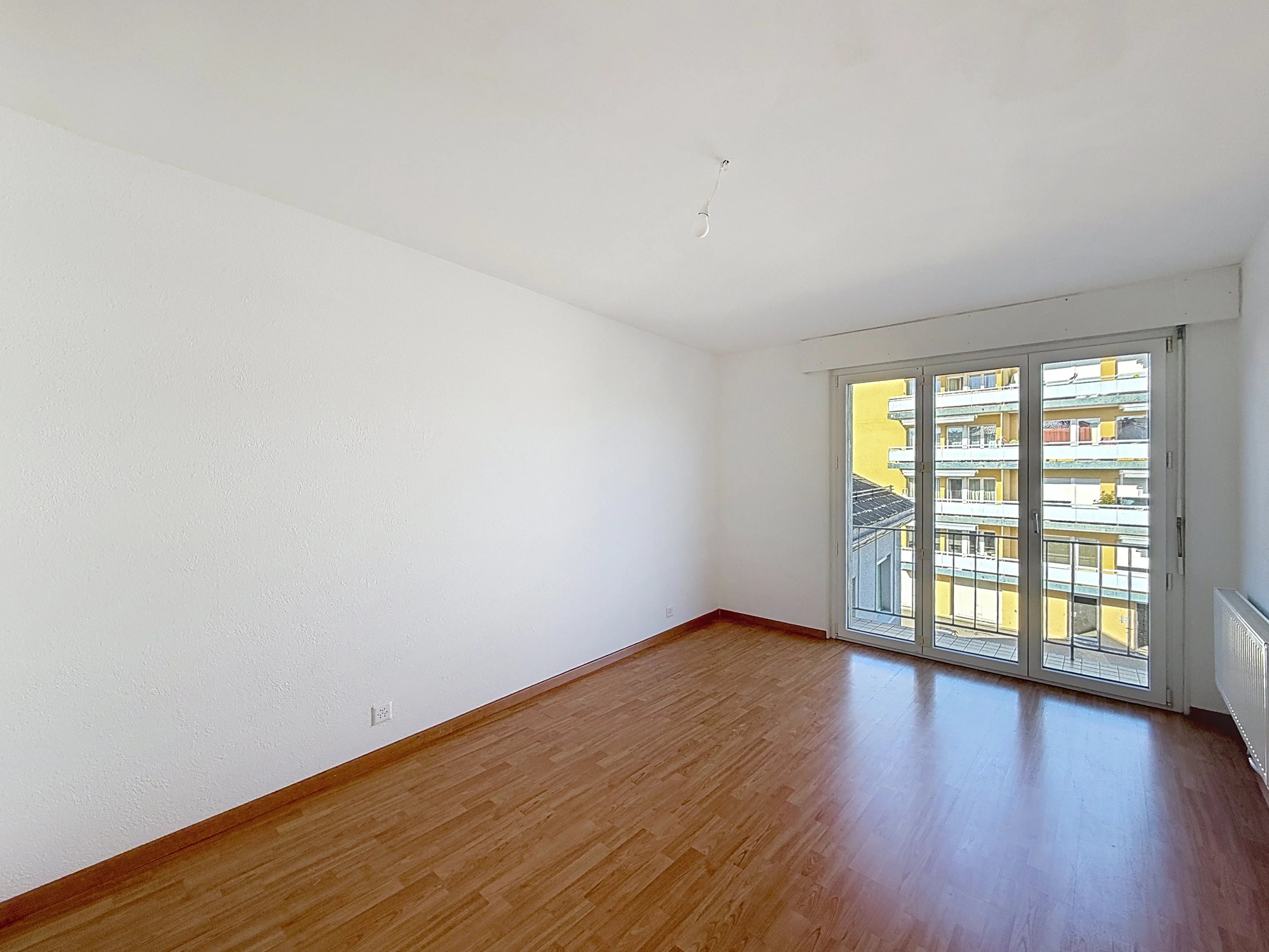 Leerer Wohnraum mit Balkonblick