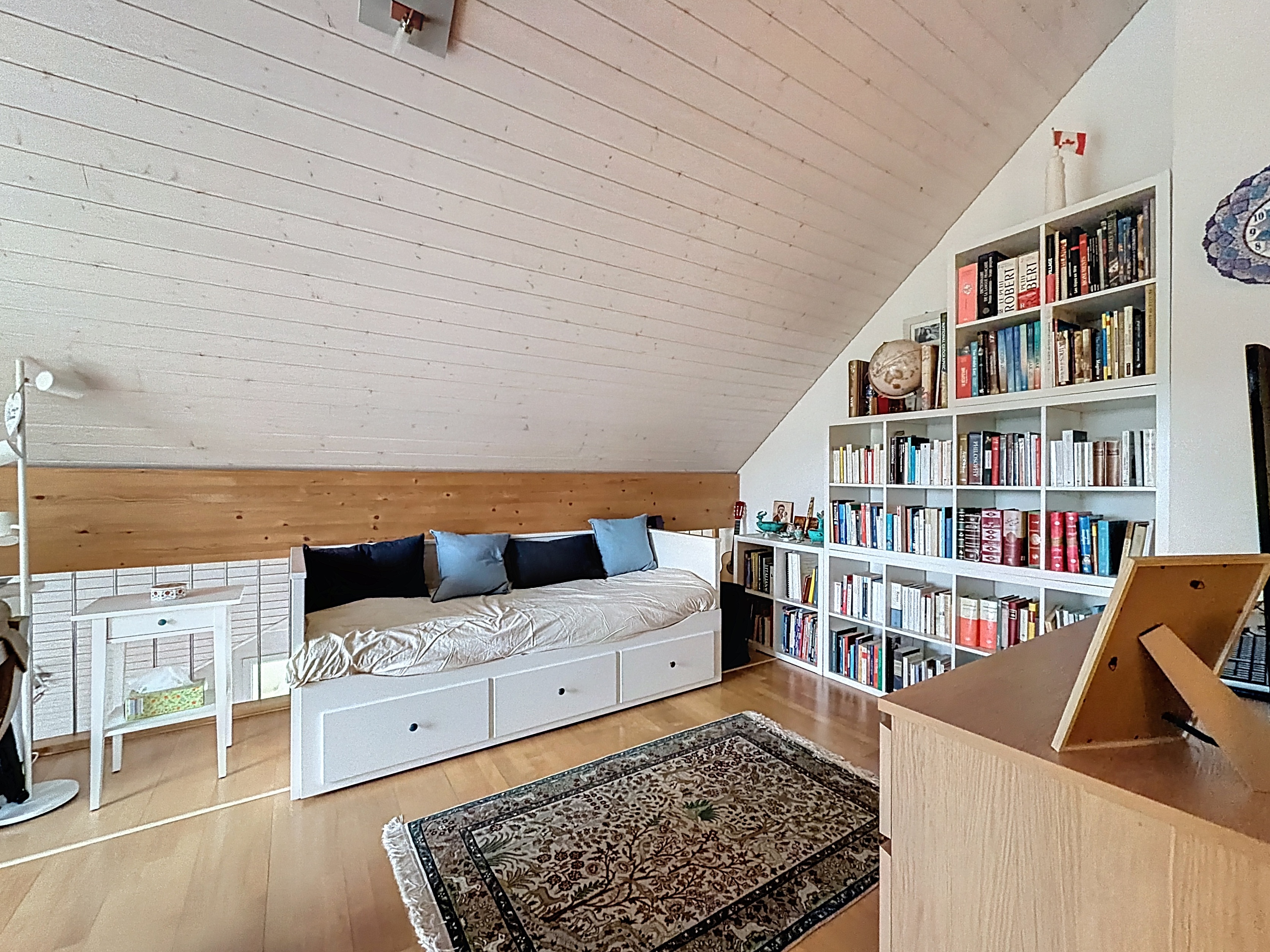 Helles Dachgeschosszimmer mit Leseecke und Bett