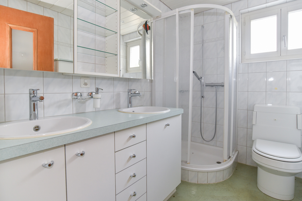 Helles Badezimmer mit Doppelwaschtisch, Dusche und WC