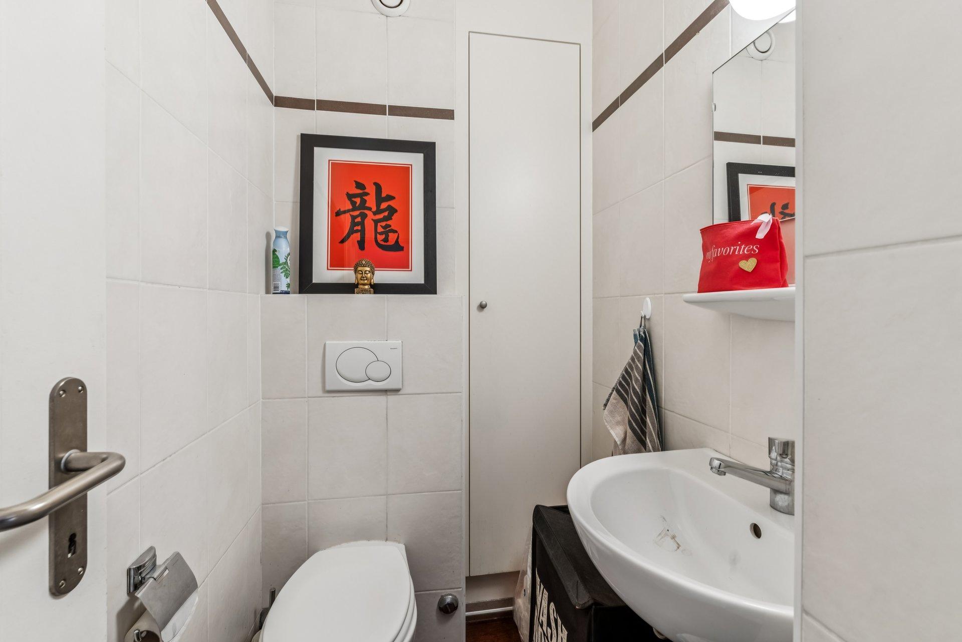 Kleines Gäste-WC mit Wandfliesen und Waschbecken