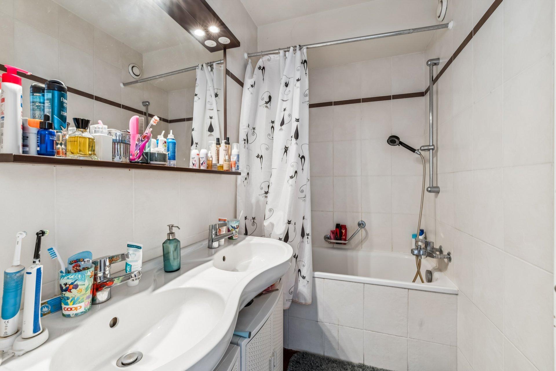 Kleines Badezimmer mit Badewanne und Doppelwaschtisch
