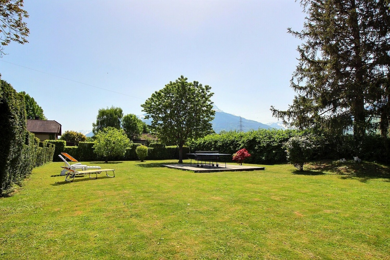 Großer Garten mit Liegestuhl und Bergblick