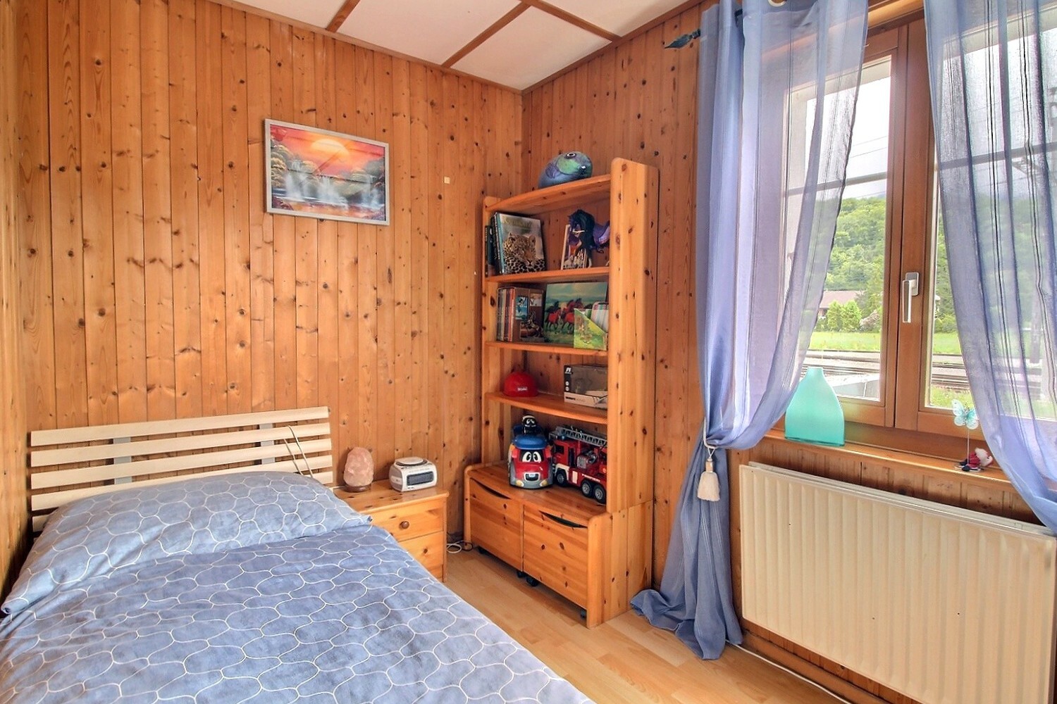 Gemütliches Schlafzimmer mit Holzverkleidung