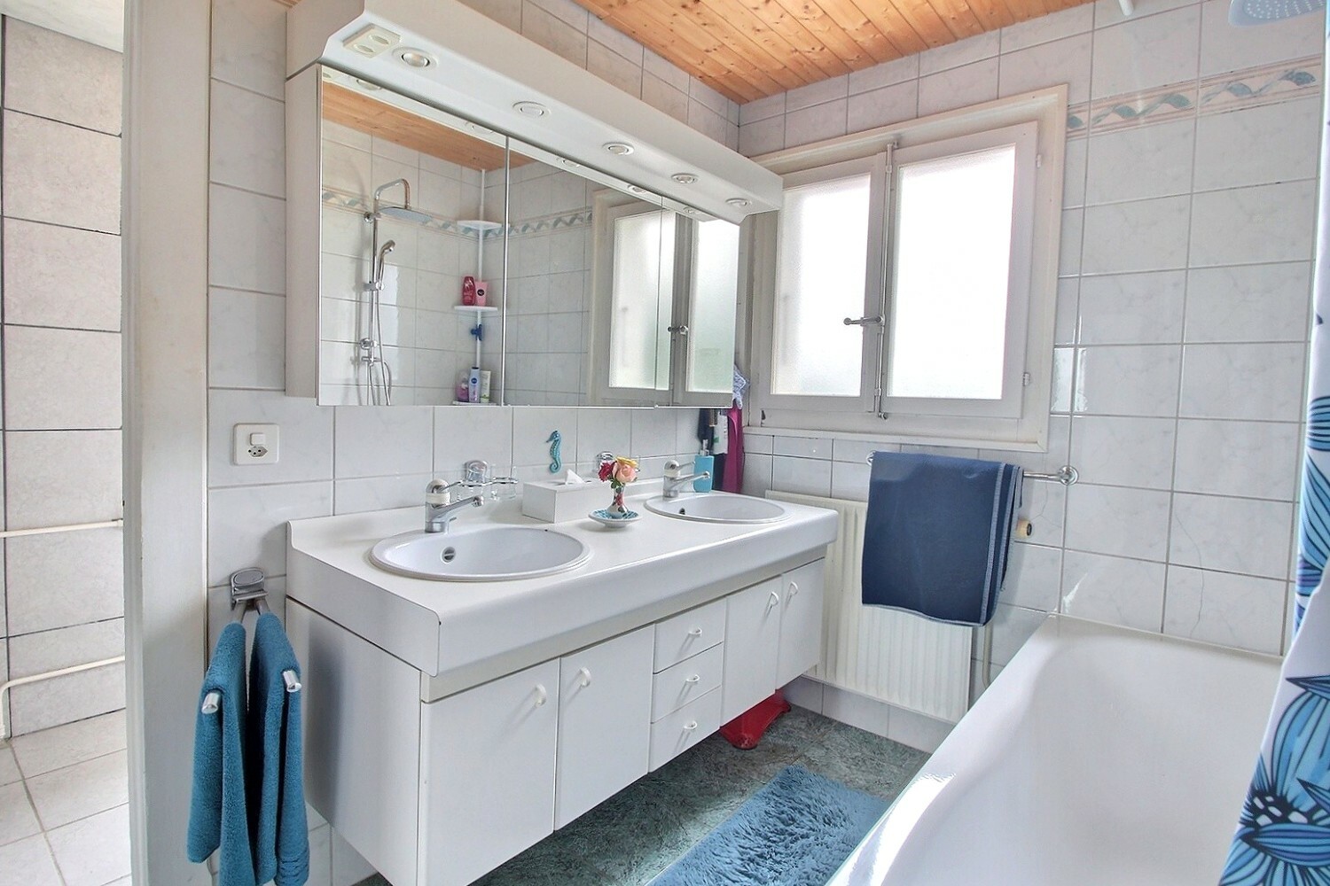 Helles Badezimmer mit Doppelwaschtisch und Badewanne