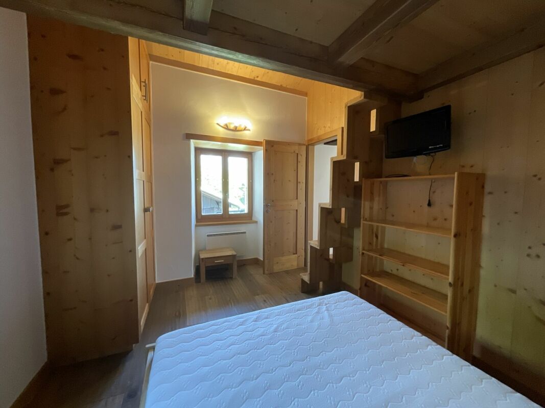 Gemütliches Holzzimmer mit Bett und Fenster