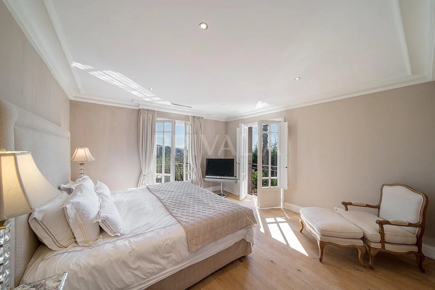 Helles Schlafzimmer mit klassischer Einrichtung und Balkonblick