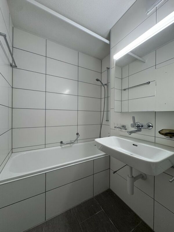 Modernes kleines Badezimmer mit Badewanne und Spiegelwaschtisch