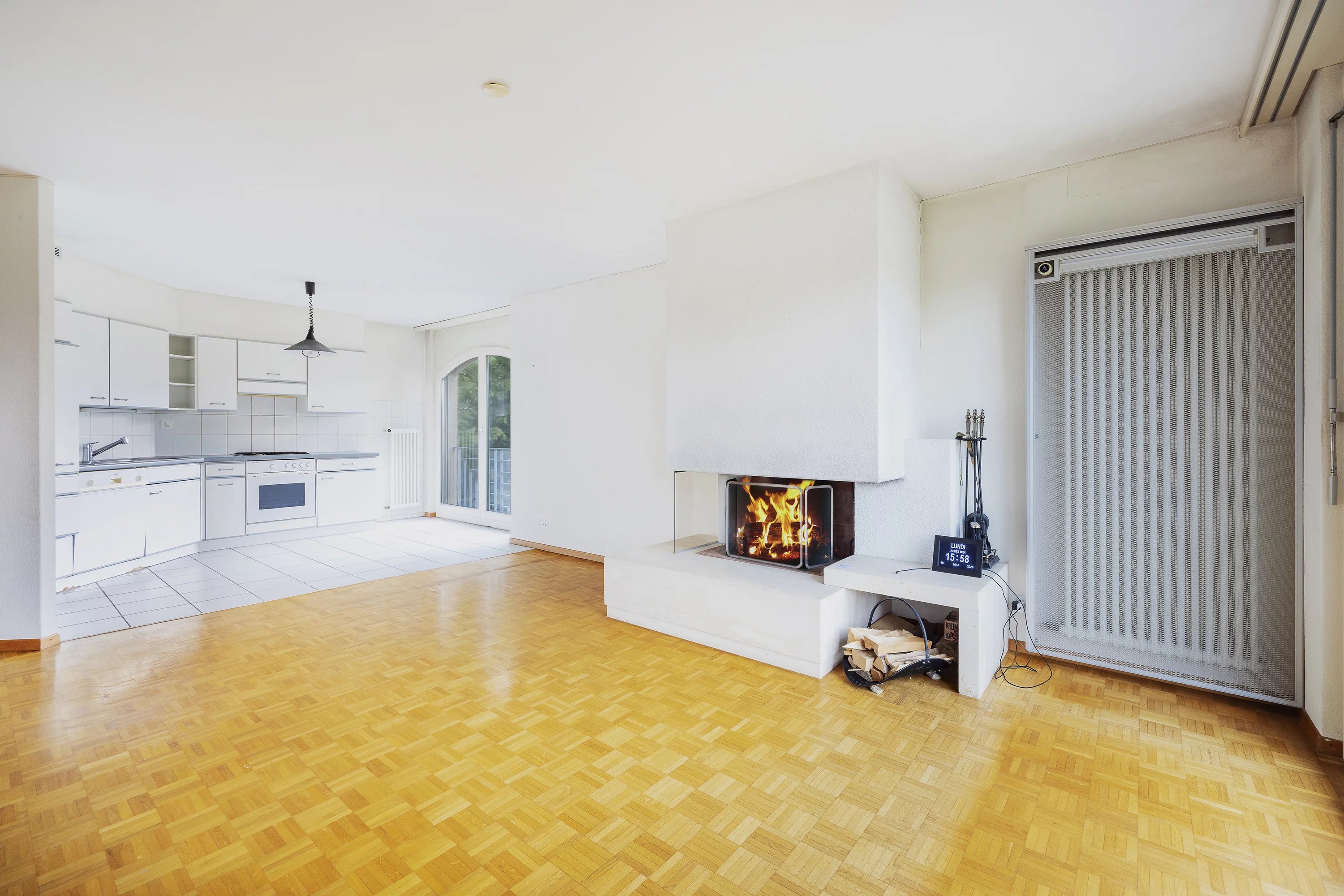 Wohnzimmer mit offener Küche und Kamin