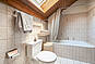 Helles Badezimmer mit Badewanne und Dachfenster