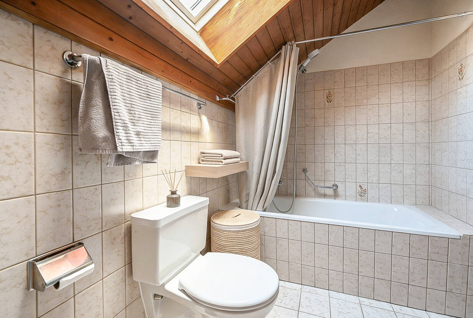 Badezimmer mit Badewanne und WC unter Dachschräge