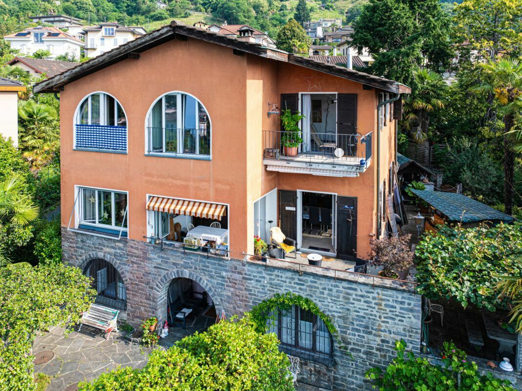 Außenansicht eines terrassierten Wohnhauses mit Balkon und Garten