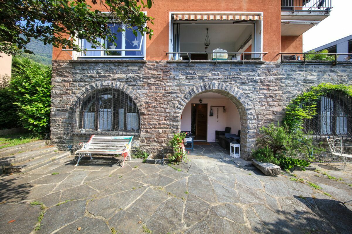 Außenansicht eines Hauses mit Naturstein-Sockel und Terrasse