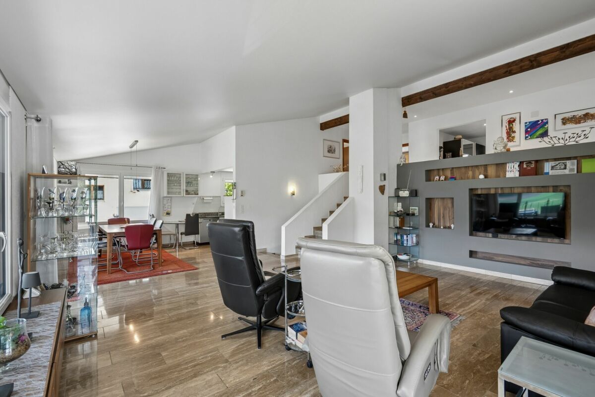 Offener Wohn-Essbereich mit Treppe und Medienwand