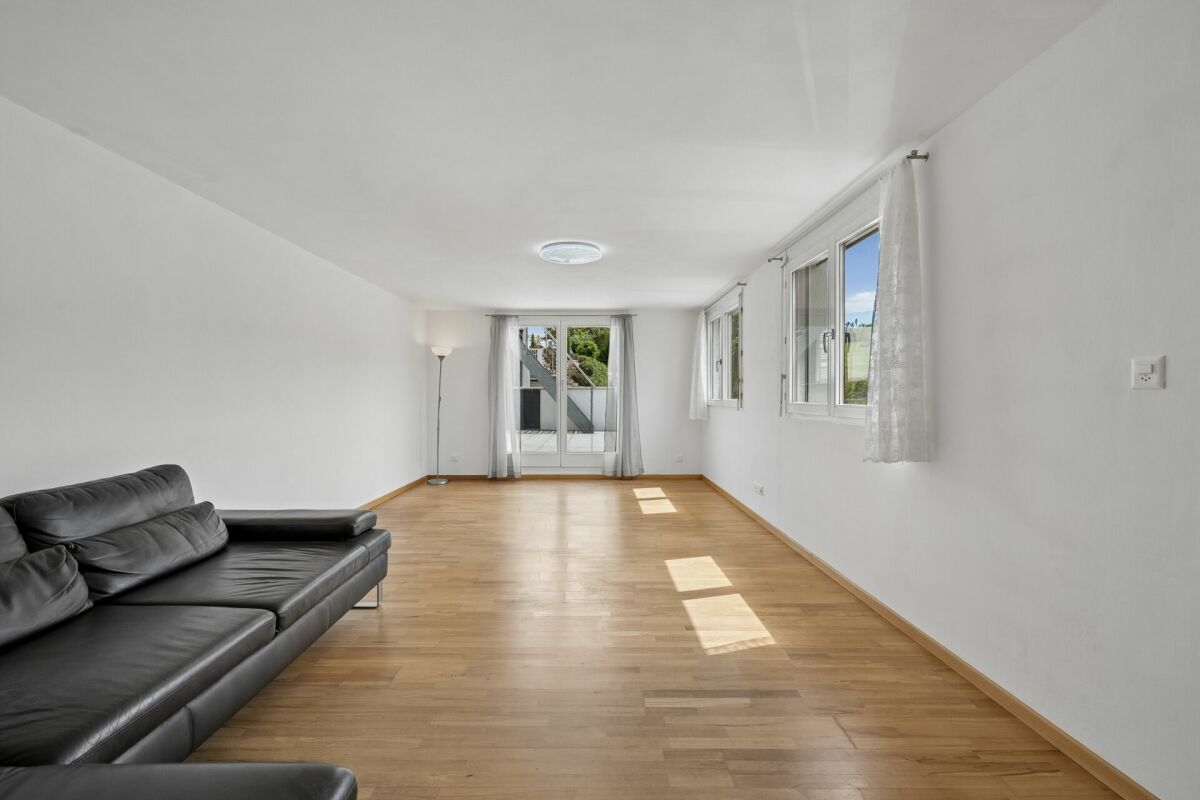 Heller Wohnraum mit Sofa und großen Fenstern