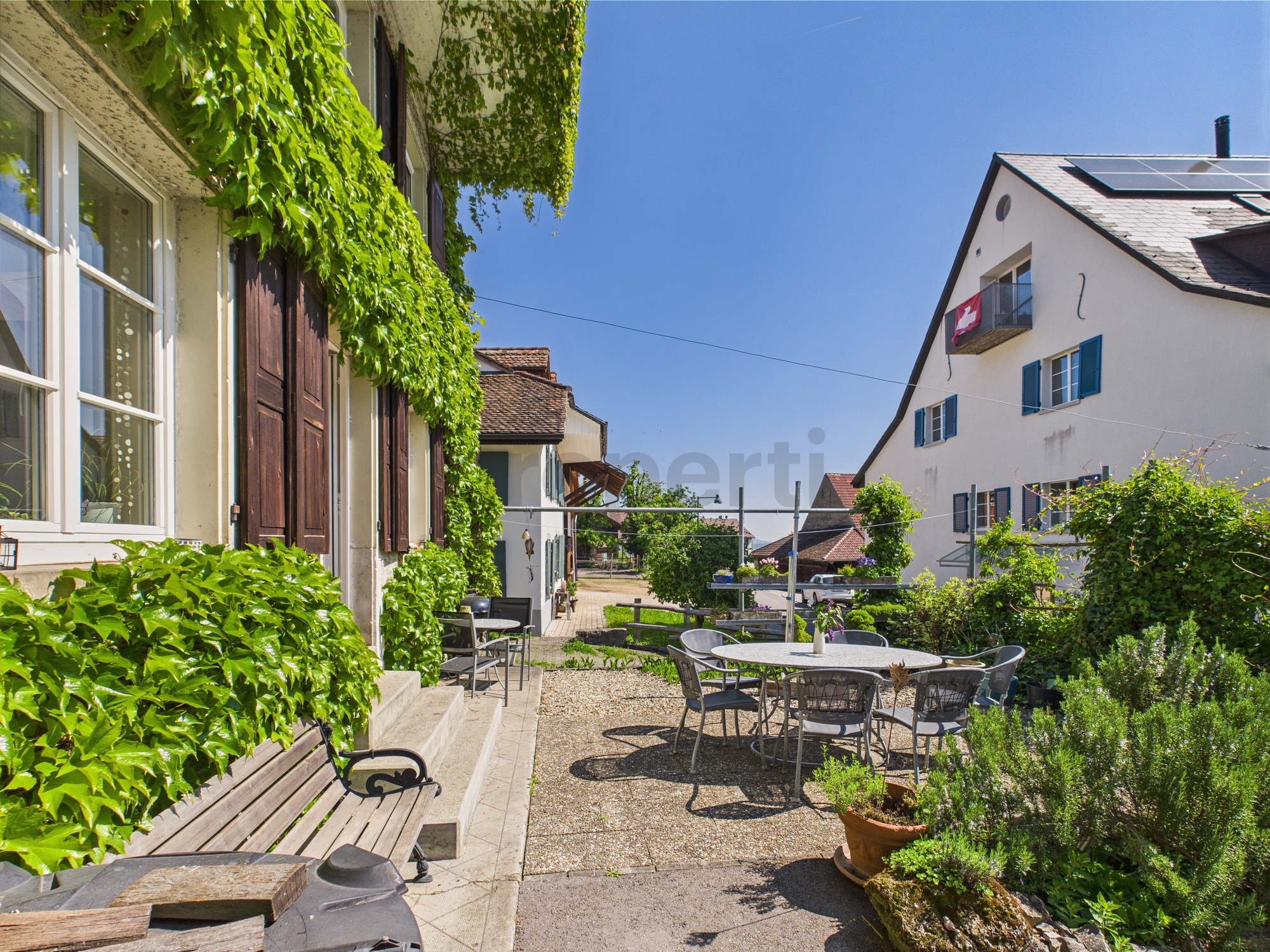 Heller Innenhof mit Sitzbereich und viel Grün