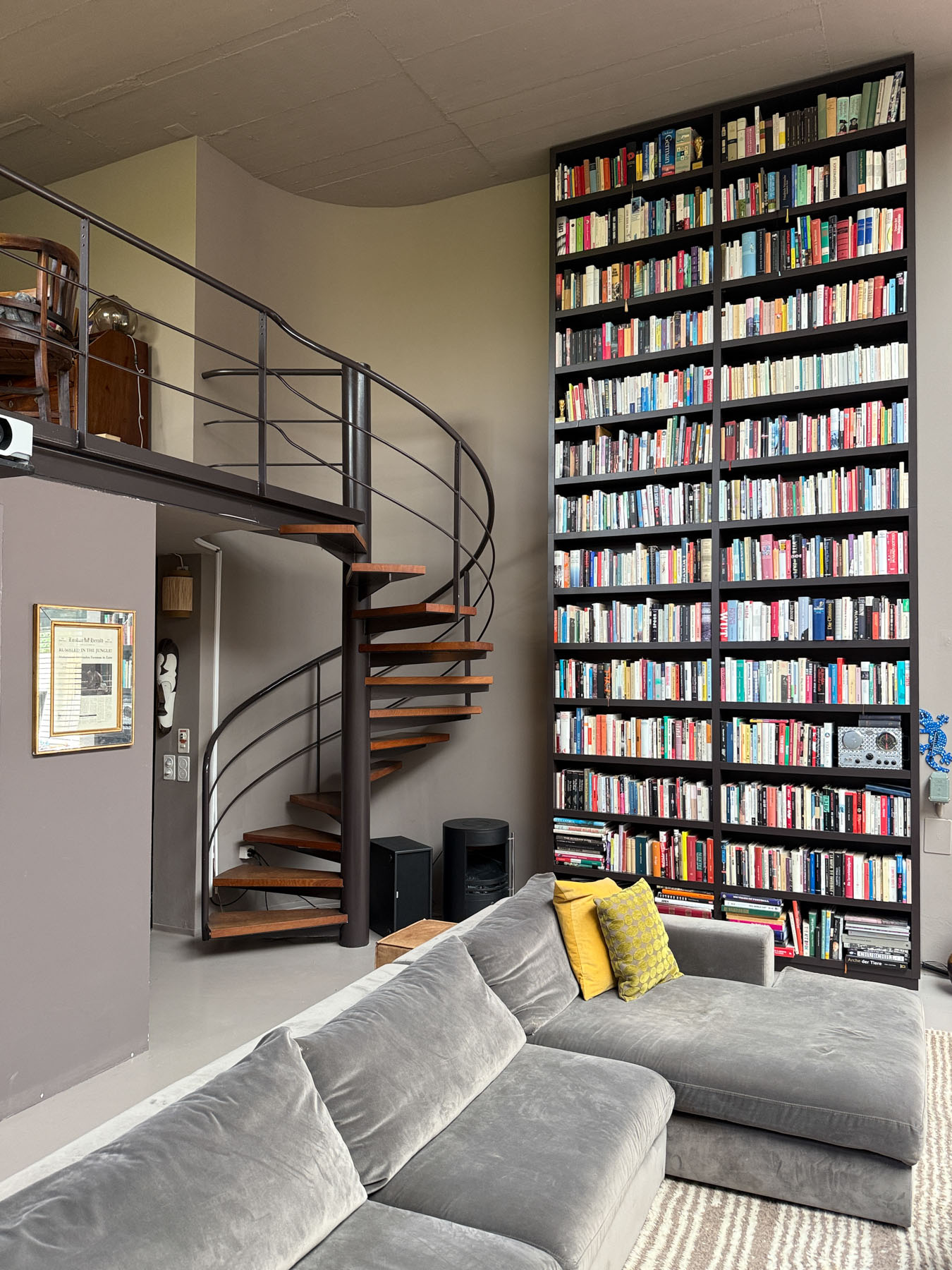 Wohnzimmer mit Bibliothekswand und Treppe