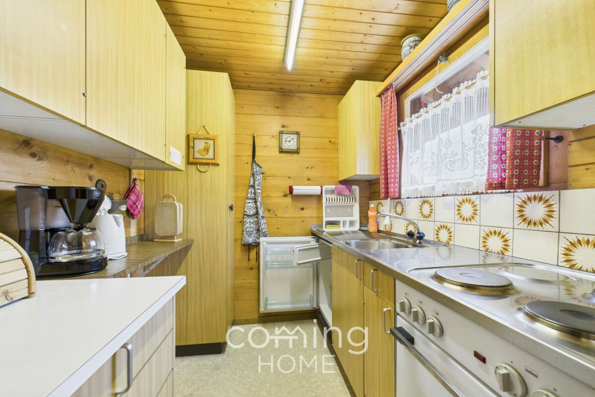 Kleine Holz-Küche mit Retro-Fliesen und Dachfenster