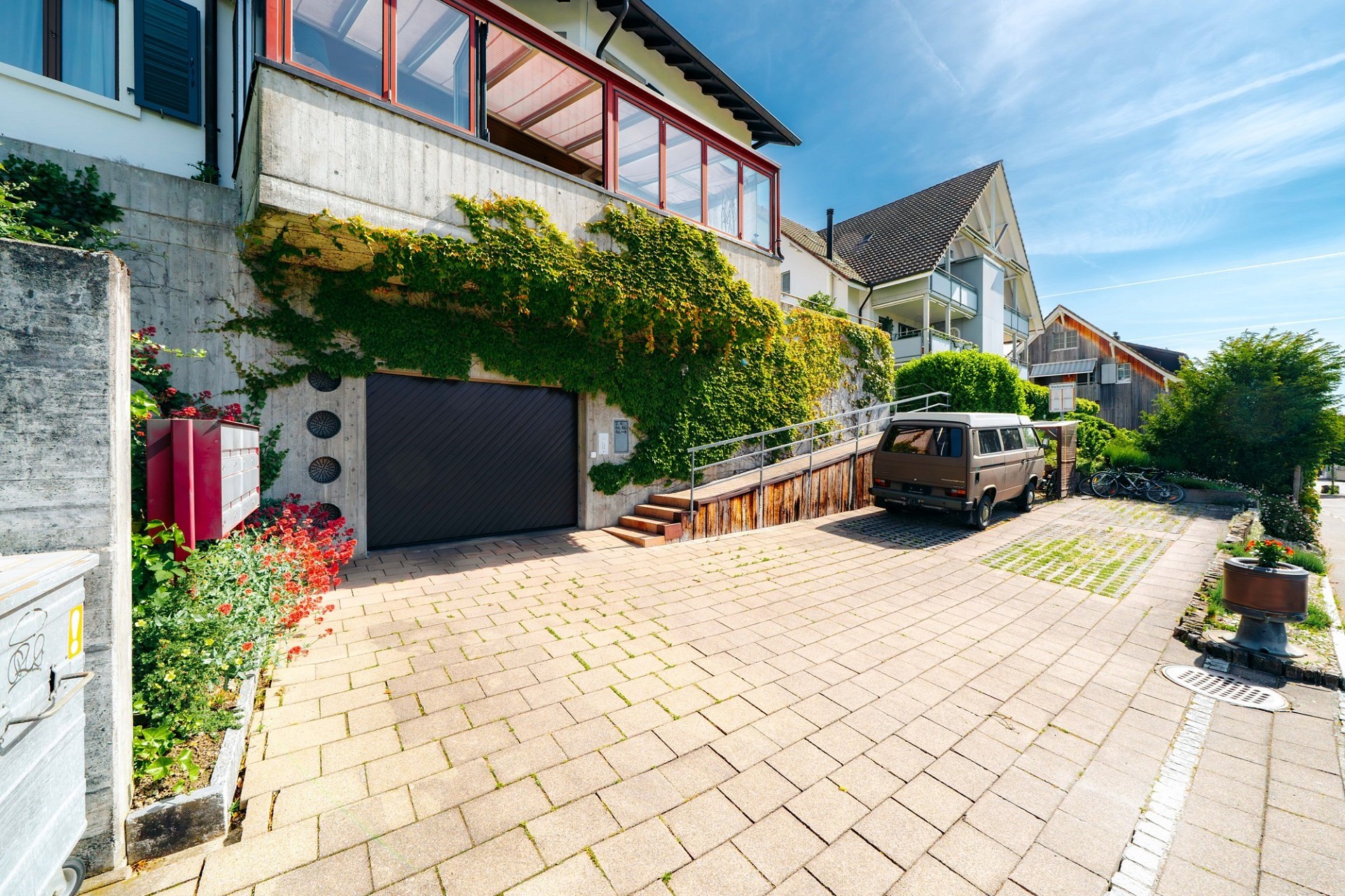 Außenansicht einer Wohnzufahrt mit Garage und Hausfassaden