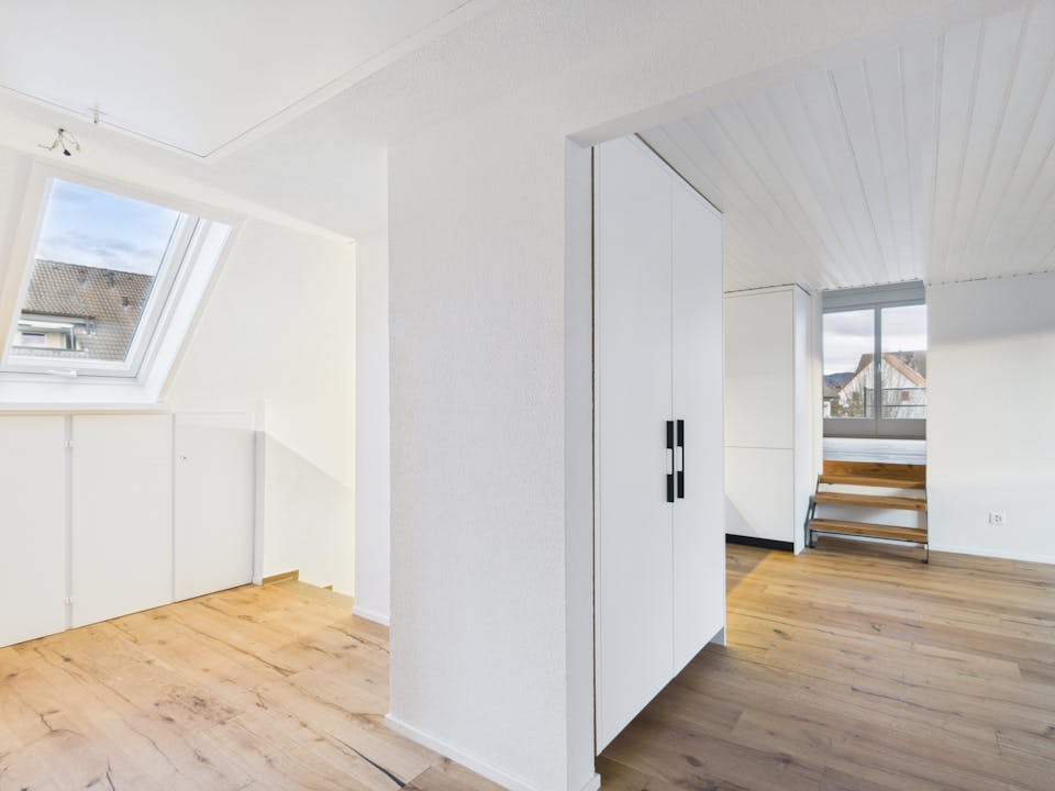 Heller Dachgeschossraum mit Dachfenster und Einbauschrank