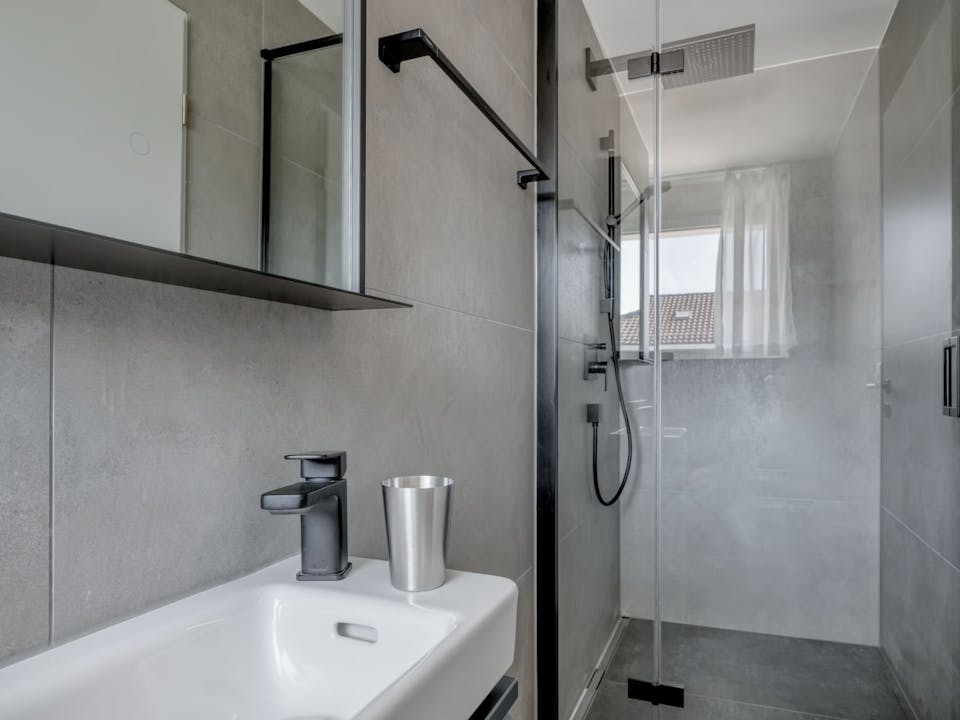 Modernes Badezimmer mit Glasdusche und Wandwaschtisch