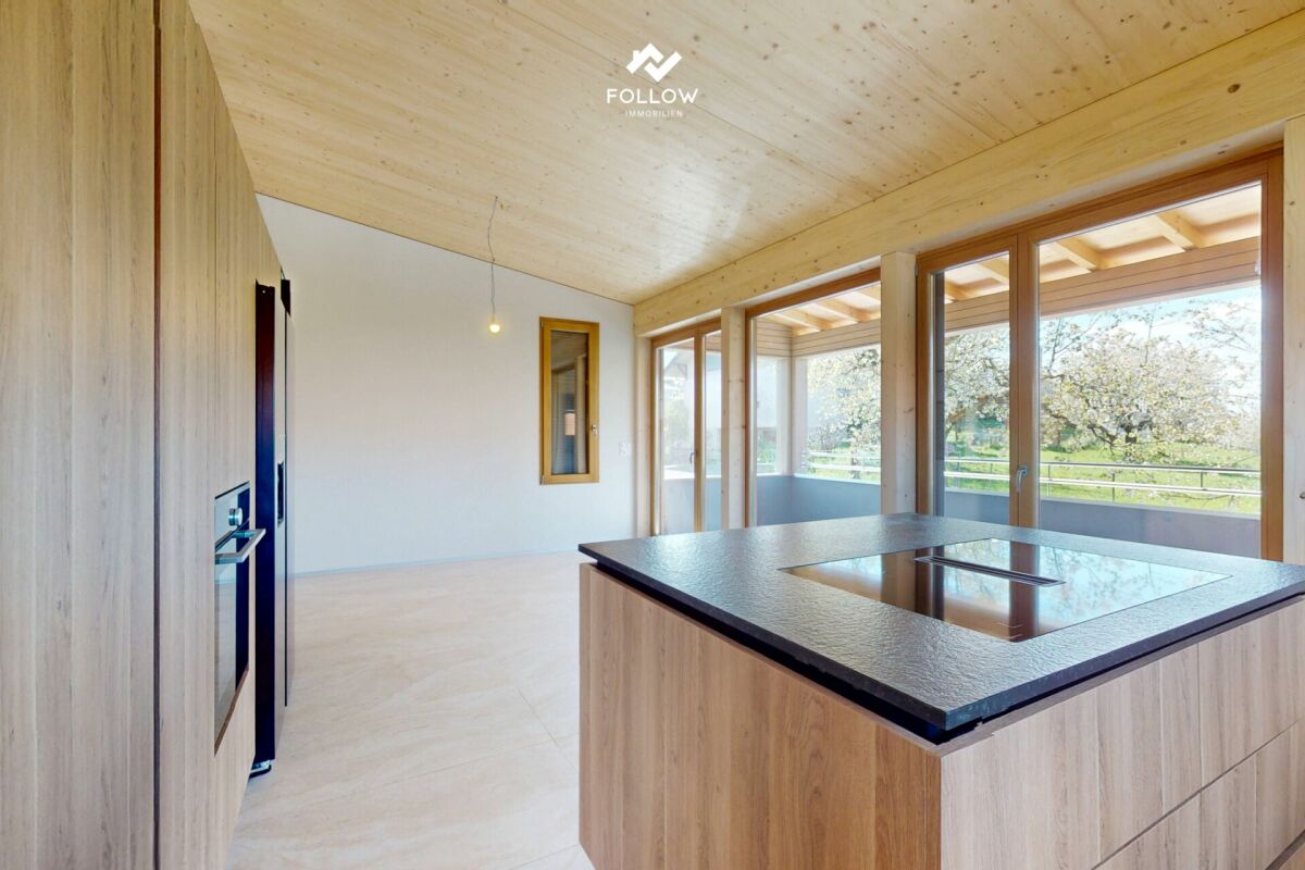 Offene moderne Wohnküche mit großen Fensterflächen