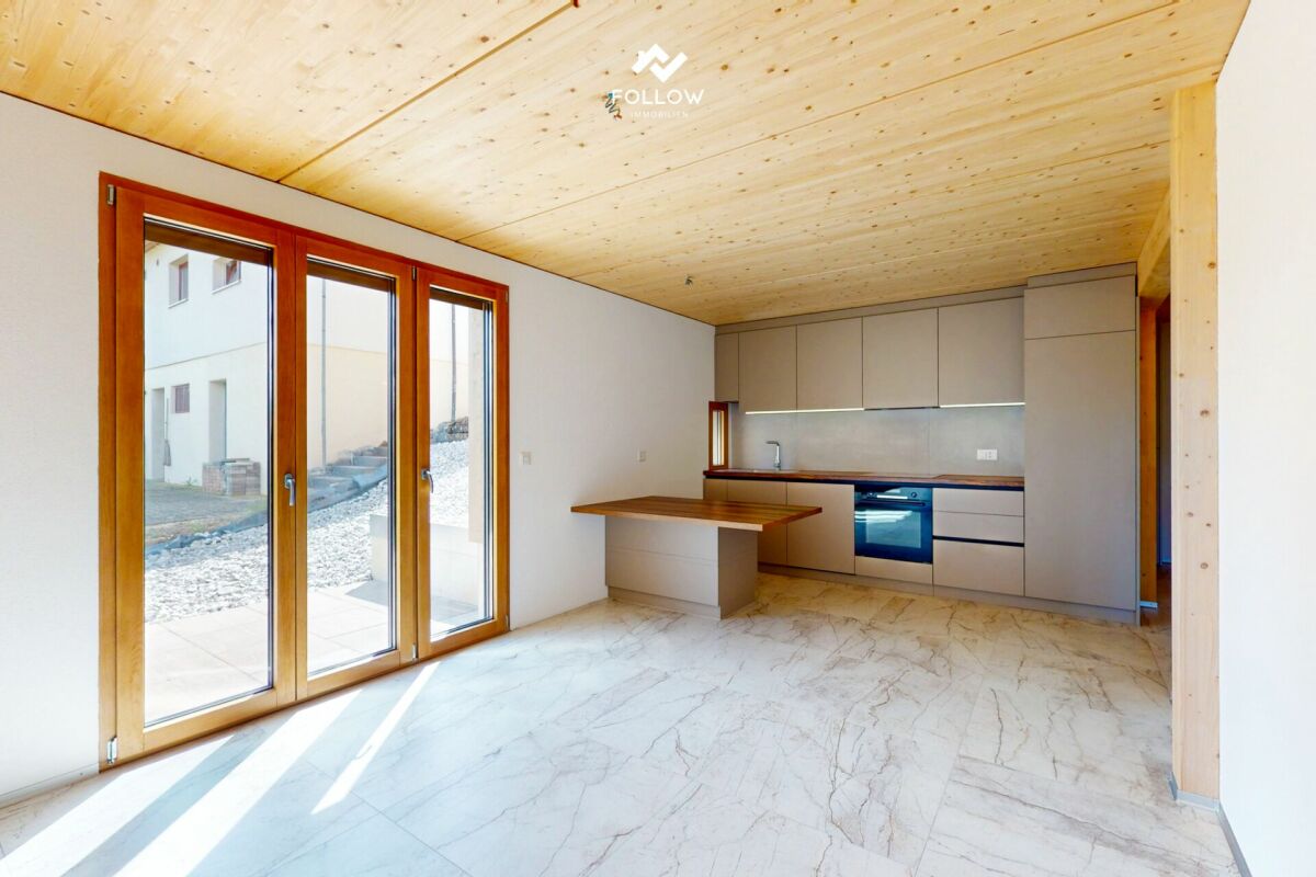 Offener Küchenraum mit Holzdecke