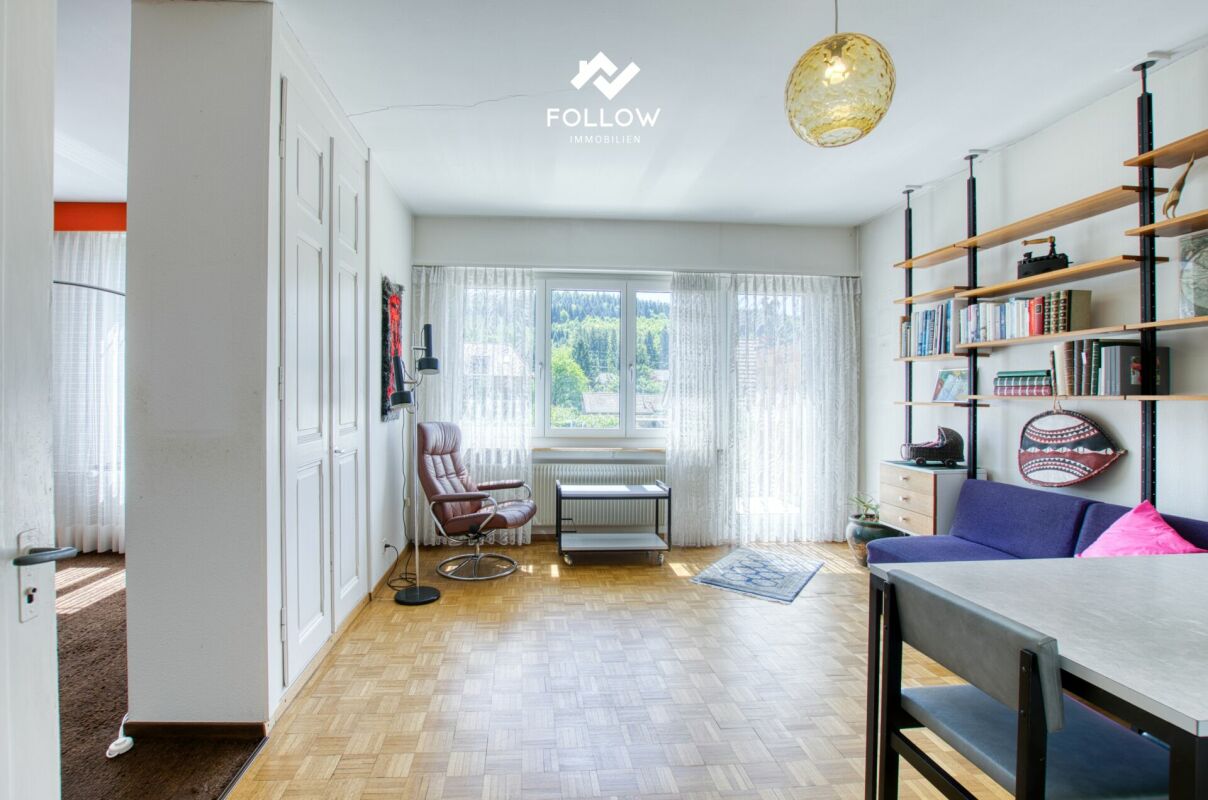 Helles Zimmer mit Fenster, Sofa und Regalen