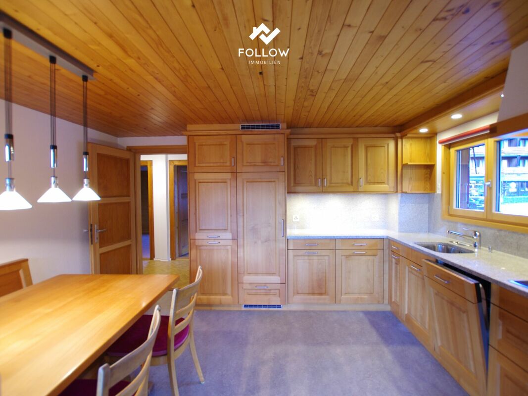 Helle Küche mit Holzdecke und Essbereich