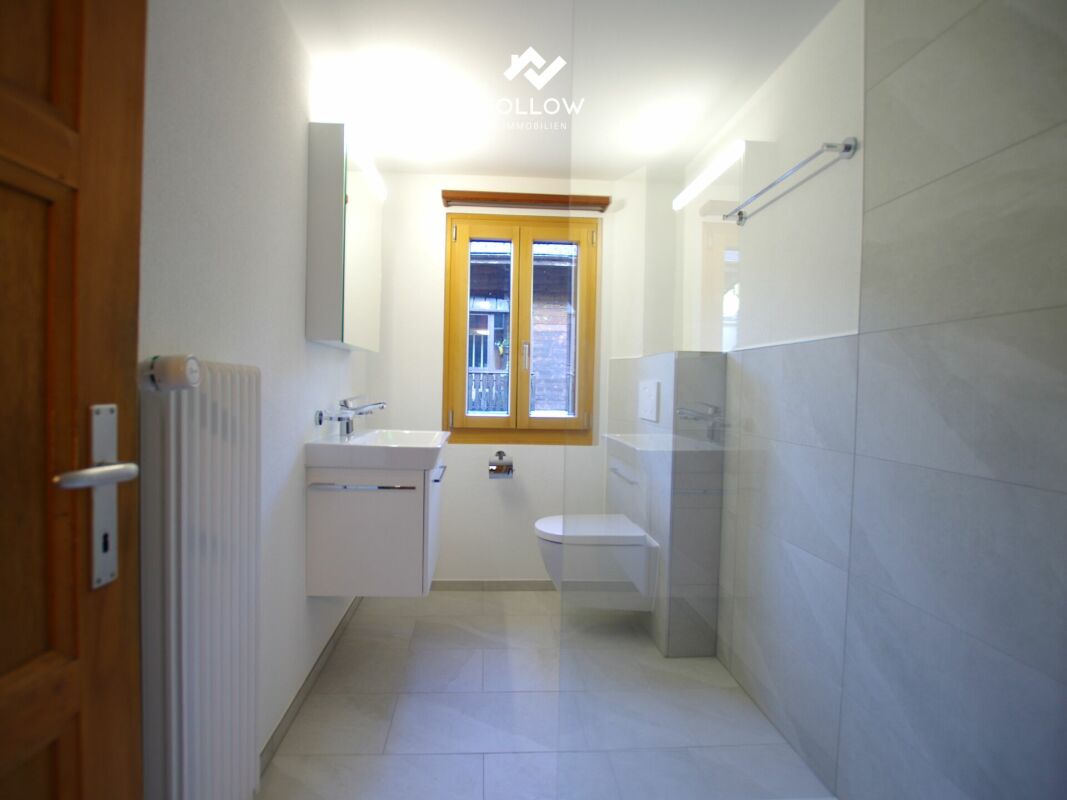 Helles Badezimmer mit Fenster und Dusche