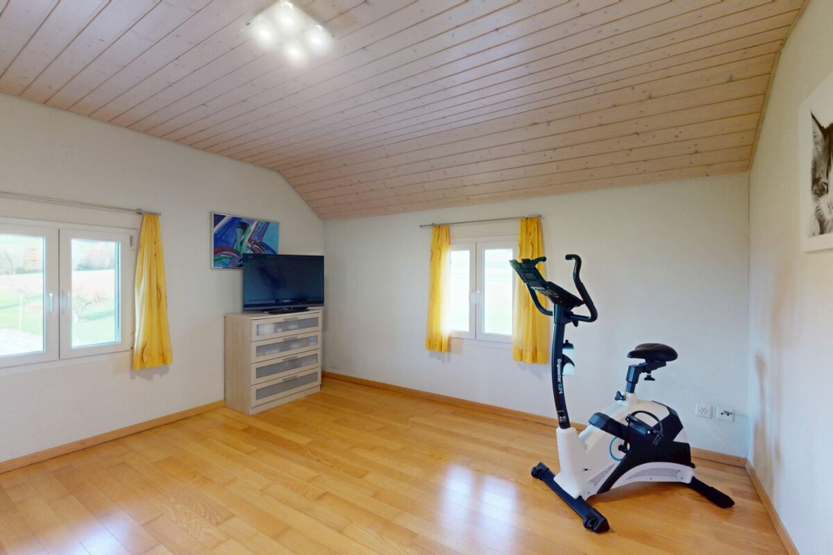 Heller Raum mit Holzdecke und Heimtrainer