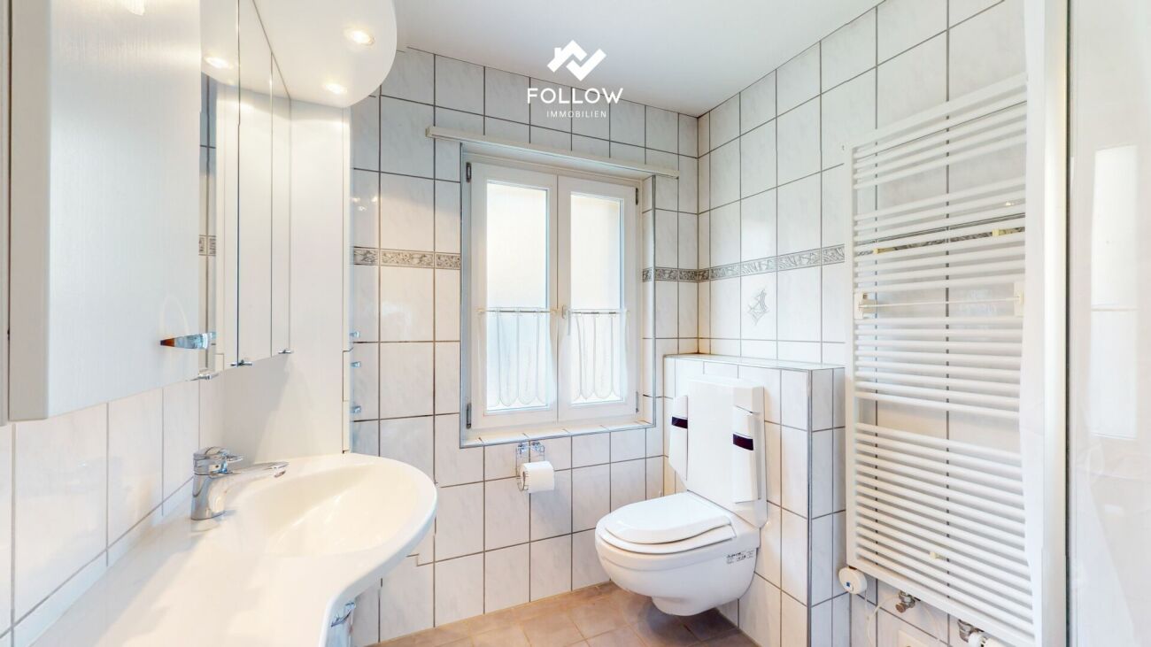 Helles Gäste-WC mit weißer Fliesenverkleidung