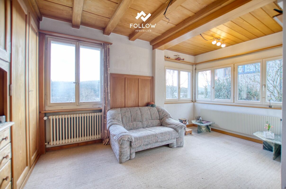 Wohnzimmer mit Holzdecke und vielen Fenstern