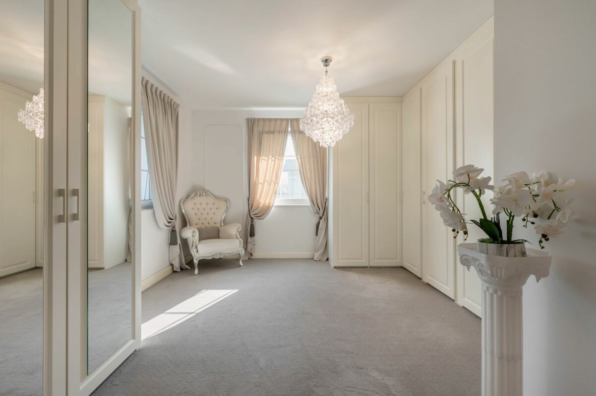 Helles, elegantes Schlafzimmer mit Einbauschränken und Kronleuchter