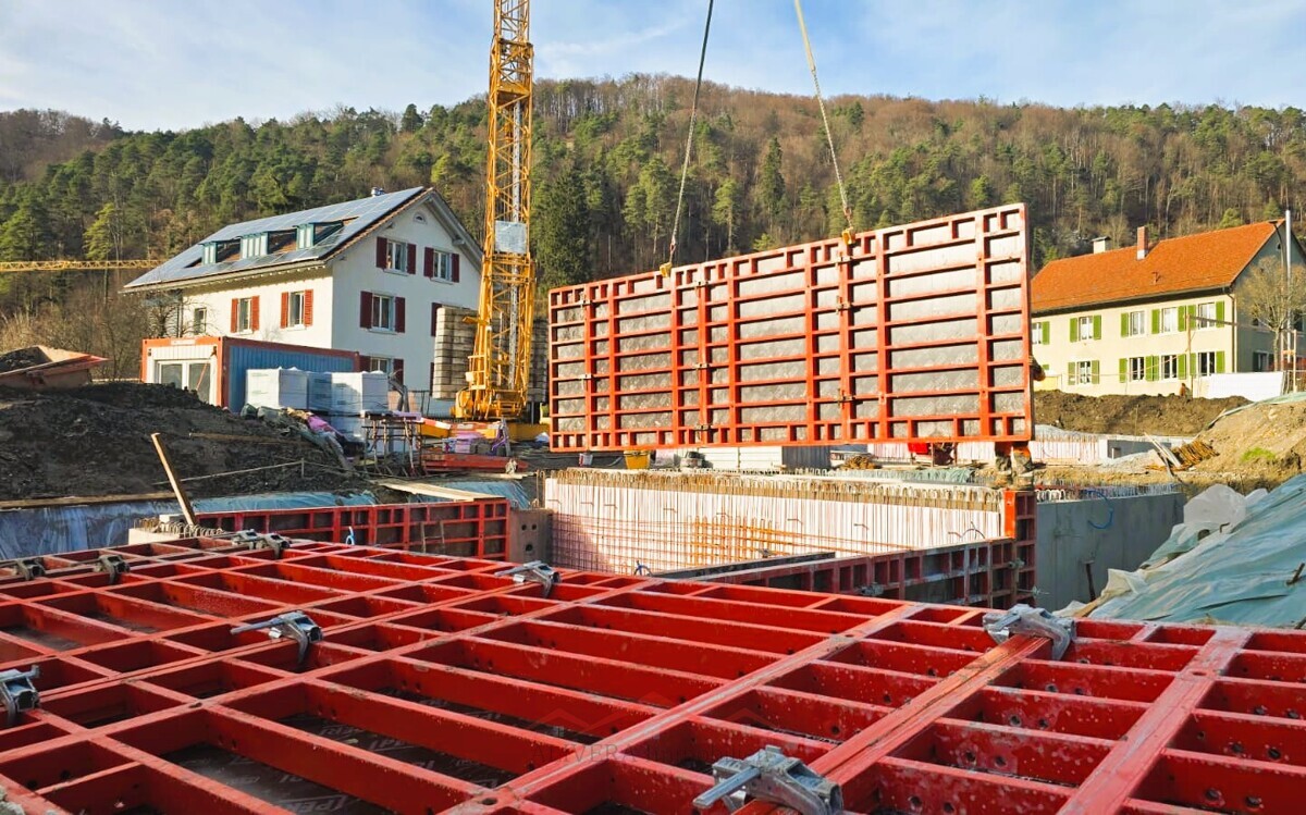 Baustelle mit Hebekran und Schalungselementen