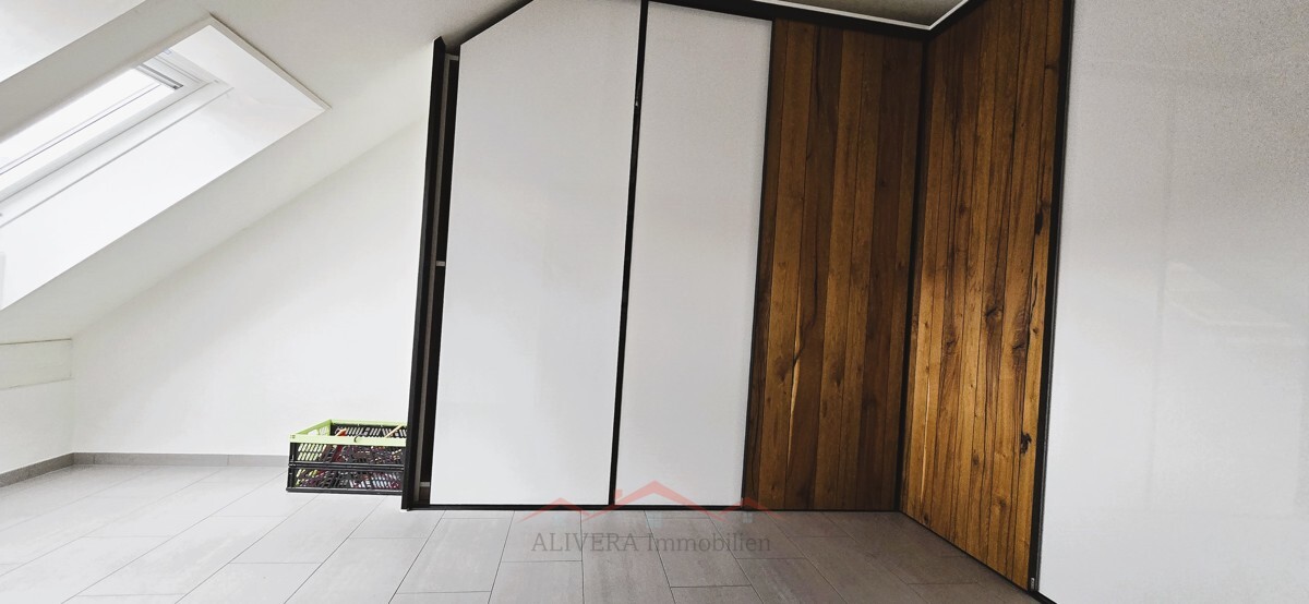 Dachgeschossraum mit Dachfenster und Einbauschrank