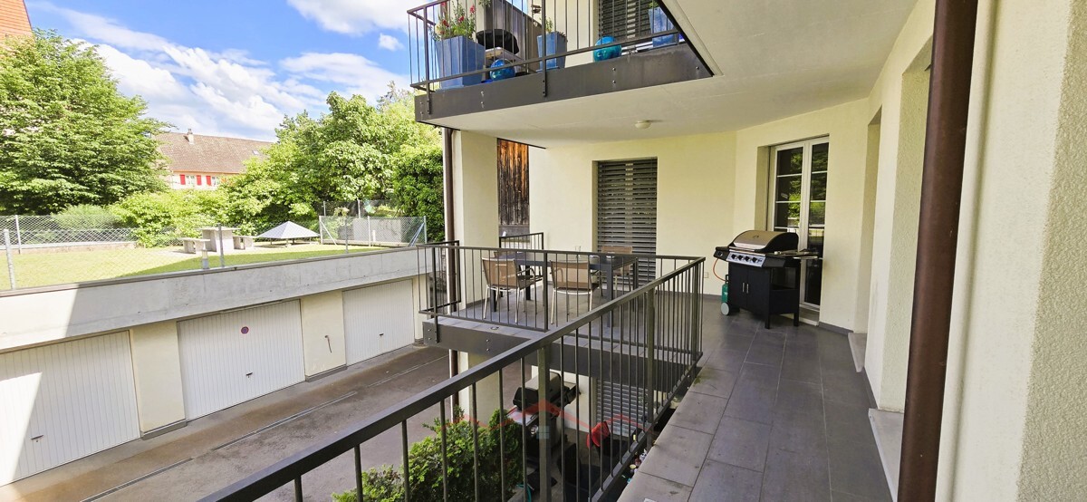 Überdachter Außenflur mit Balkon und Garage