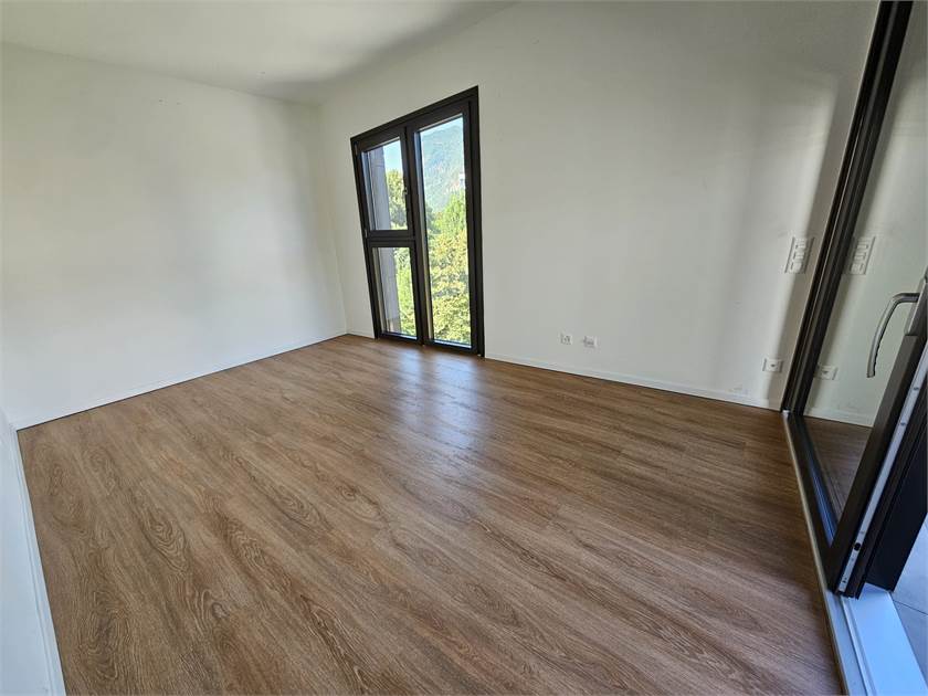 Leerer, heller Raum mit Holzoptikboden