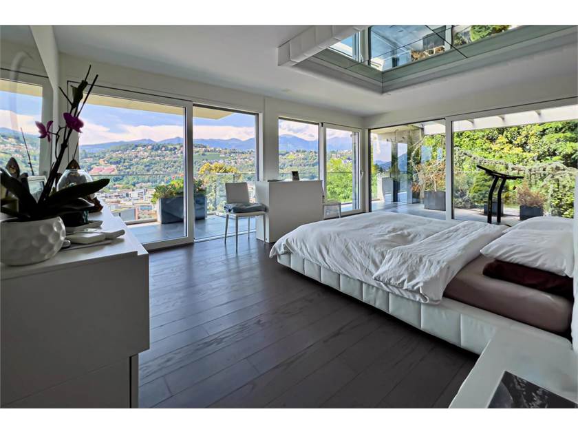 Schlafzimmer mit Panoramafenstern und Dachöffnung