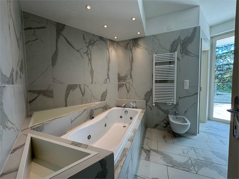 Luxuriöses Badezimmer mit freistehender Wanne und Marmoroptik