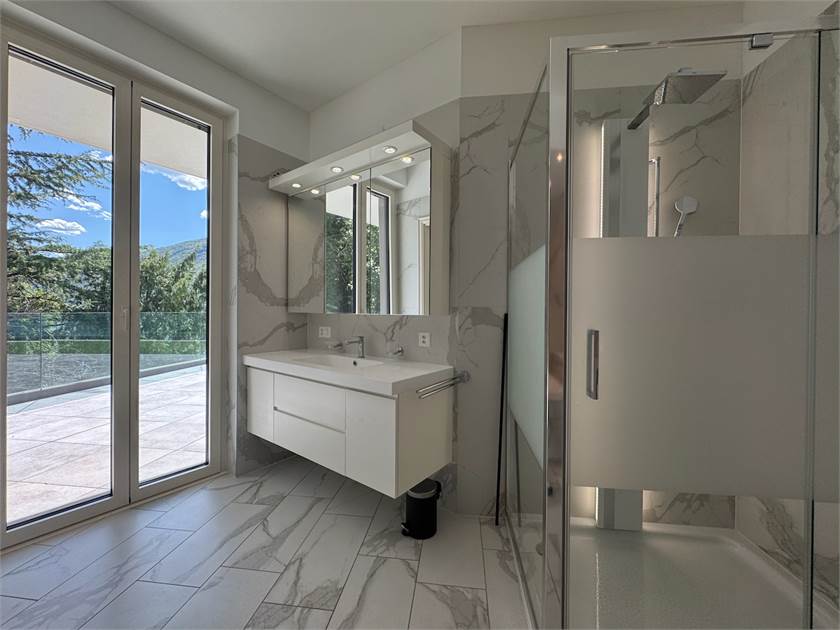 Modernes Badezimmer mit bodentiefen Fenstern und Dusche