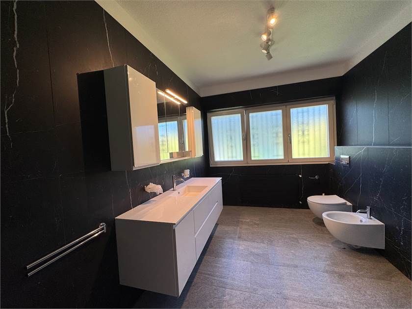 Modernes Badezimmer mit dunkler Wandverkleidung und Doppelwaschbecken