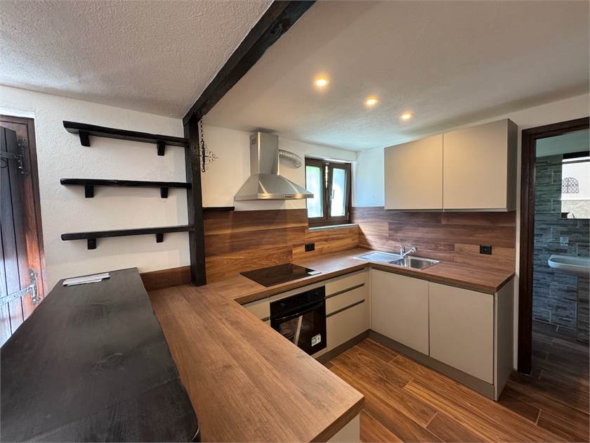 Moderne Eckküche mit Holzoptik und kleinen Fenstern