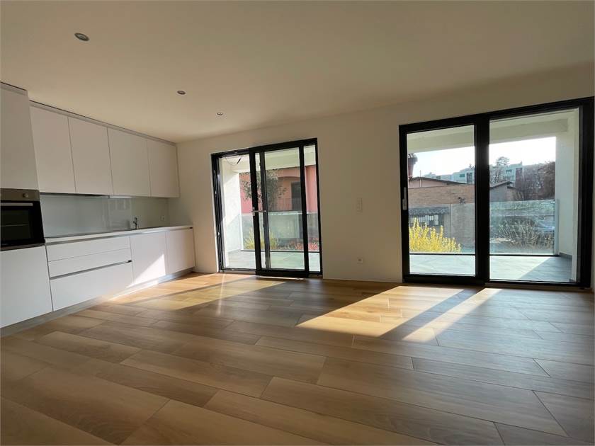 Offener Wohnraum mit Küche und großen Fenstertüren