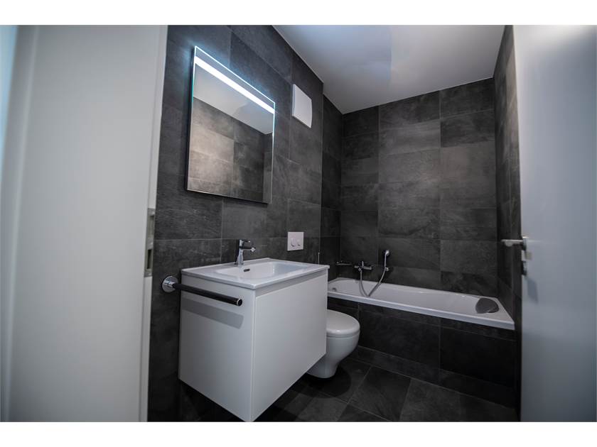 Modernes dunkles Badezimmer mit Badewanne und Waschtisch