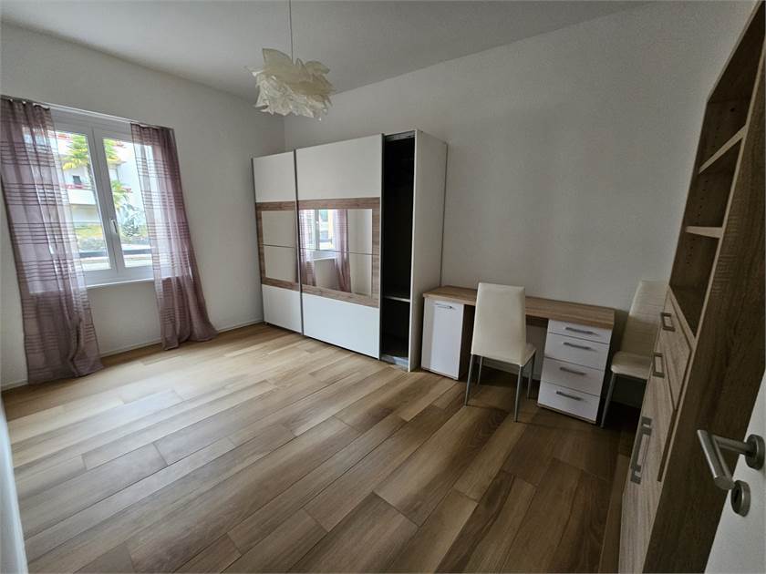 Helles Schlafzimmer mit Schreibtisch und Kleiderschrank